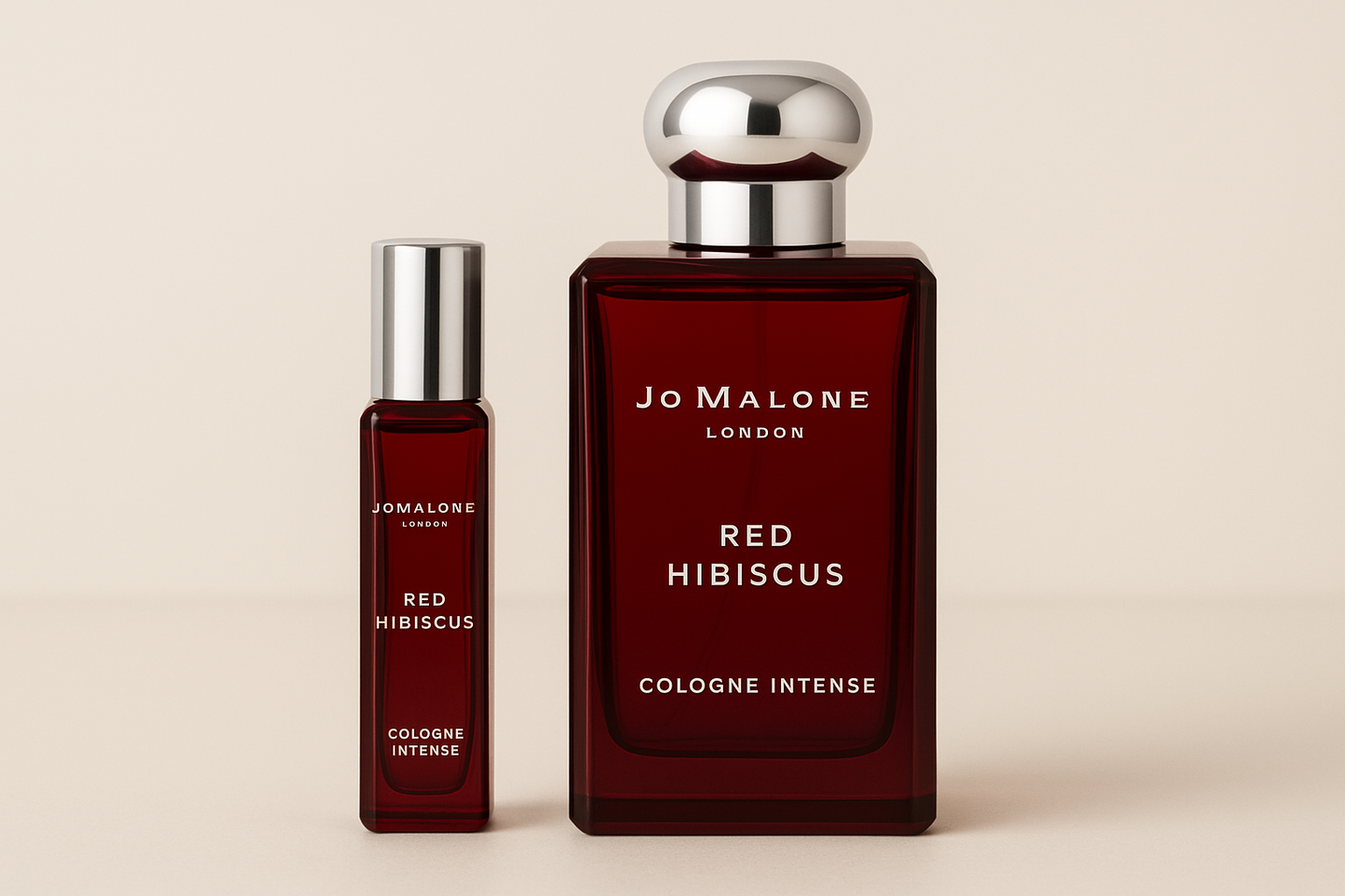 Jo Malone Red Hibiscus Cologne Intense 12ml sample standing next to 100ml perfume bottle of Jo Malone Red Hibiscus Cologne Intense which has white writing on dark red bottle